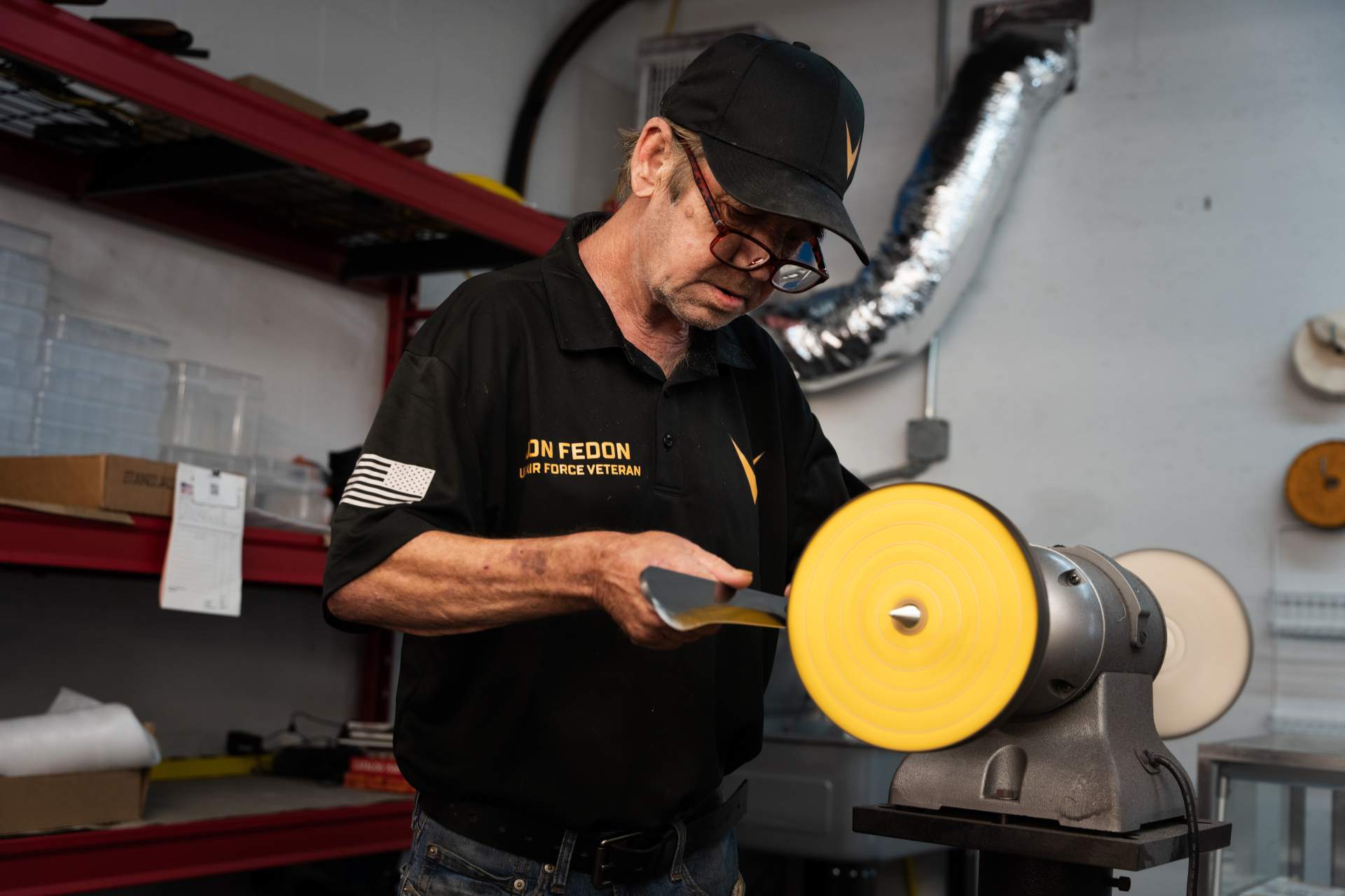 Gentleman in Bevel uniform sharpening an axe.